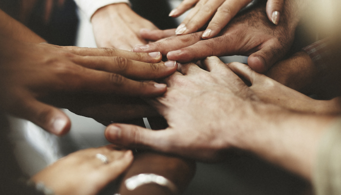 Hands of people positioned in the middle.