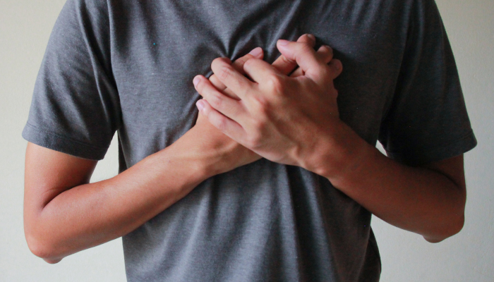 Person hand is on the heart.